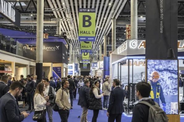 Feria gastronómica internacional con expositores y visitantes profesionales en un pabellón comercial.